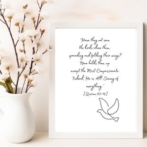 May include: A white framed print with a black and white illustration of a bird. The print features a quote from the Quran, "Have they not seen the birds above them, spreading and folding their wings? None holds them up except the Most Compassionate. Indeed, He is All-Seeing of everything." [Quran 67:19]