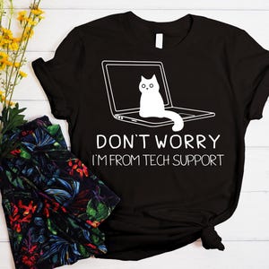 May include: Black t-shirt with a white graphic of a cat sitting on a laptop. The text "Don't worry I'm from tech support" is printed below the image.