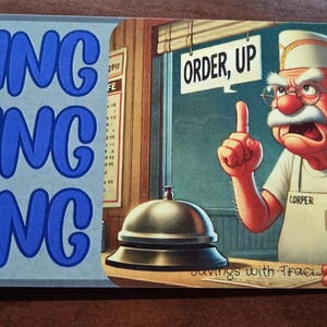 May include: A diner-themed metal sign with the words "DING DING DING" in blue on a light blue background. The right side features a cartoon of a chef pointing upwards, with a bell and the words "ORDER, UP".