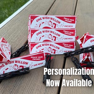 May include: Several red and white rectangular boxes labeled ONE WISH WILLOW with the text AMAZE YOUR FRIENDS and ONE WISH. The boxes feature a cartoon illustration and are accompanied by black, elongated, hollow plastic components with a lattice design.