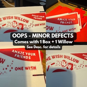 Puede incluir: Una caja de cart&oacute;n blanca con gr&aacute;ficos impresos en rojo que incluyen el texto THE WISH WILLOW, AMAZE YOUR FRIENDS y ONE WISH. El dise&ntilde;o presenta ilustraciones estilizadas de dos rostros rodeados de peque&ntilde;as formas de estrellas.