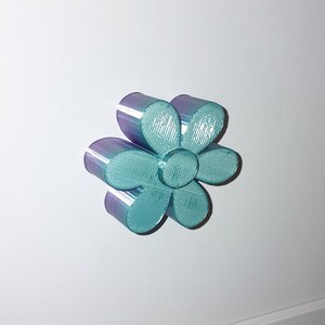 May include: A teal and purple iridescent flower-shaped cabinet knob.