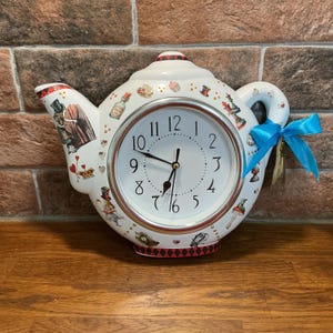 Alice in Wonderland themed decoupage wall clock. Plastic lightweight. Shaped like a teapot. Teapot clock Alice in Wonderland