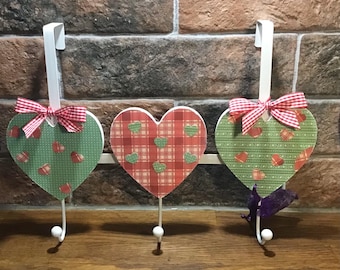 Ganchos para colgar sobre la puerta con forma de corazón decorados con decoupage: decoración rústica y elegante.