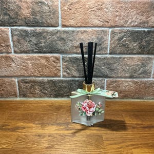 Elegante fles met rietverspreider van matglas met vintage bloemenprints