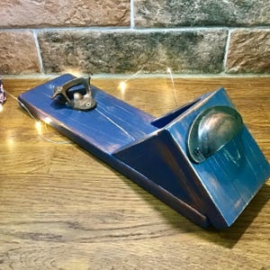 Può includere: Un apribottiglie in legno blu montato a parete con una maniglia in rame e un apribottiglie incorporato.