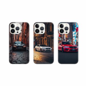 Könnte beinhalten: Drei Handyhüllen mit verschiedenen Designs, die ein weißes Auto, ein rotes Auto und ein schwarzes Auto in einer Stadtkulisse zeigen.