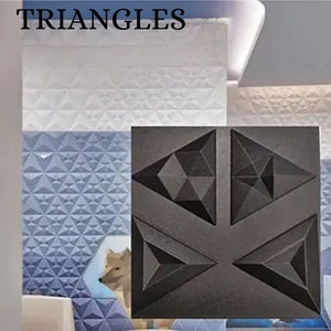 Puede incluir: Un azulejo cuadrado negro con cuatro formas triangulares en relieve. Cada triángulo tiene un patrón geométrico de triángulos más pequeños. El azulejo está sobre un fondo de azulejos con patrones azules y blancos. La palabra "TRIANGLES" está escrita en letras negras en la parte superior de la imagen.