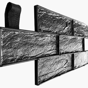 Puede incluir: Molde de goma negro para crear un patrón de pared de piedra. El molde está hecho de goma flexible y tiene una superficie texturizada que se asemeja a piedra apilada. El molde está diseñado para ser utilizado con concreto u otros materiales de fundición.