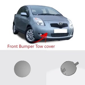 May include: A silver front bumper tow cover for a car. The cover is round and has a small lip around the edge. The cover is shown next to a silver car.