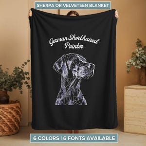 May include: Black blanket with a geometric illustration of a German Shorthaired Pointer dog. The blanket has the text "German Shorthaired Pointer" in white script. The blanket also has the text "6 COLORS | 6 FONTS AVAILABLE".