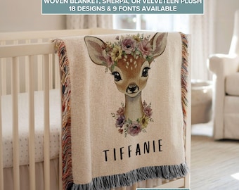 May include: A beige woven blanket with a deer graphic wearing a floral crown. The blanket has a fringe trim and the name "TIFFANIE" printed in black. Text at the top reads "WOVEN BLANKET, SHERPA, OR VELVETEEN PLUSH" and "18 DESIGNS & 9 FONTS AVAILABLE".