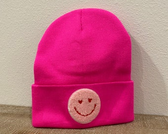 Neon pink smiley face patch with heart eyes beanie