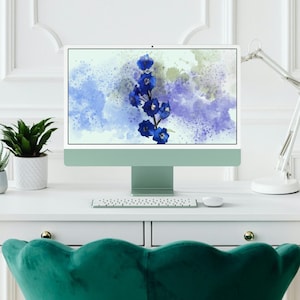 May include: A white desktop computer with a blue watercolor floral design on the screen. The computer is on a white desk with a keyboard and a lamp. There is a green plant in a white pot on the desk.