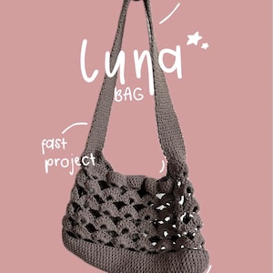 Könnte beinhalten: Gehäkelte Luna-Tasche in Braun mit einem markanten offenen Webmuster. Die Tasche hat einen langen Riemen und trägt den weißen Schriftzug "Luna BAG". Zusätzlicher Text weist auf ein "fast project" und ein "crochet pattern" hin. Von @lenileostudio.