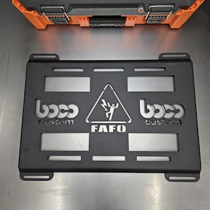 May include: A rectangular black metal molle panel featuring laser-cut details. The design includes the text boco custom on both sides, a central triangle icon depicting a person with a lightning bolt, and the text FAFO below the triangle icon.