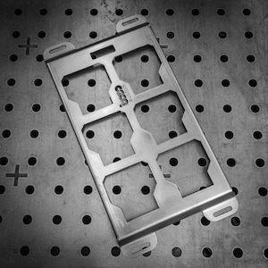 May include: A rectangular silver-toned metal frame featuring six open square cutouts arranged in two columns. The frame has four mounting slots at the corners and the word custom is engraved in the center. The surface has a brushed finish.