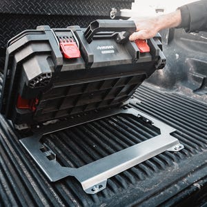 Könnte beinhalten: Schwarze Husky-Werkzeugkiste mit roten Verschlüssen und einem Griff, die auf einer silbernen Metallhalterung ruht. Die Werkzeugkiste befindet sich in der Ladefläche eines Lastwagens. Das Husky-Logo ist sichtbar.