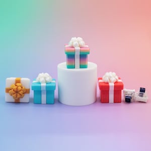 May include: A collection of colorful gift boxes with white bows. The boxes are in various colors, including white, blue, red, and a rainbow gradient. Some boxes have gold or white ribbons. The gifts are arranged on a gradient background.