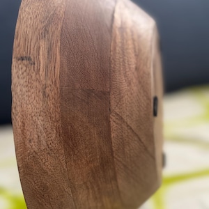 Op de afbeelding: Een houten kom met een natuurlijke, warme bruine kleur. De kom heeft een glad, gebogen ontwerp en een zichtbare houtnerftextuur. De kom wordt waarschijnlijk gebruikt om voedsel in te serveren of als decoratief stuk.