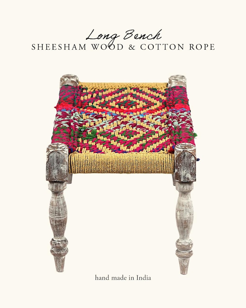 May include: A long bench made of sheesham wood and cotton rope. The seat features a vibrant, geometric pattern in red, pink, yellow, and green. The legs are painted white with a distressed finish. The text "Long Bench" and "hand made in India" are visible.