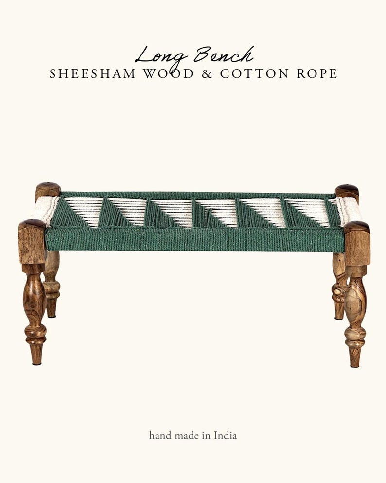 May include: A long bench made of sheesham wood and cotton rope. The bench has a woven green and white seat, supported by four carved wooden legs. The text "Long Bench" and "hand made in India" are visible.