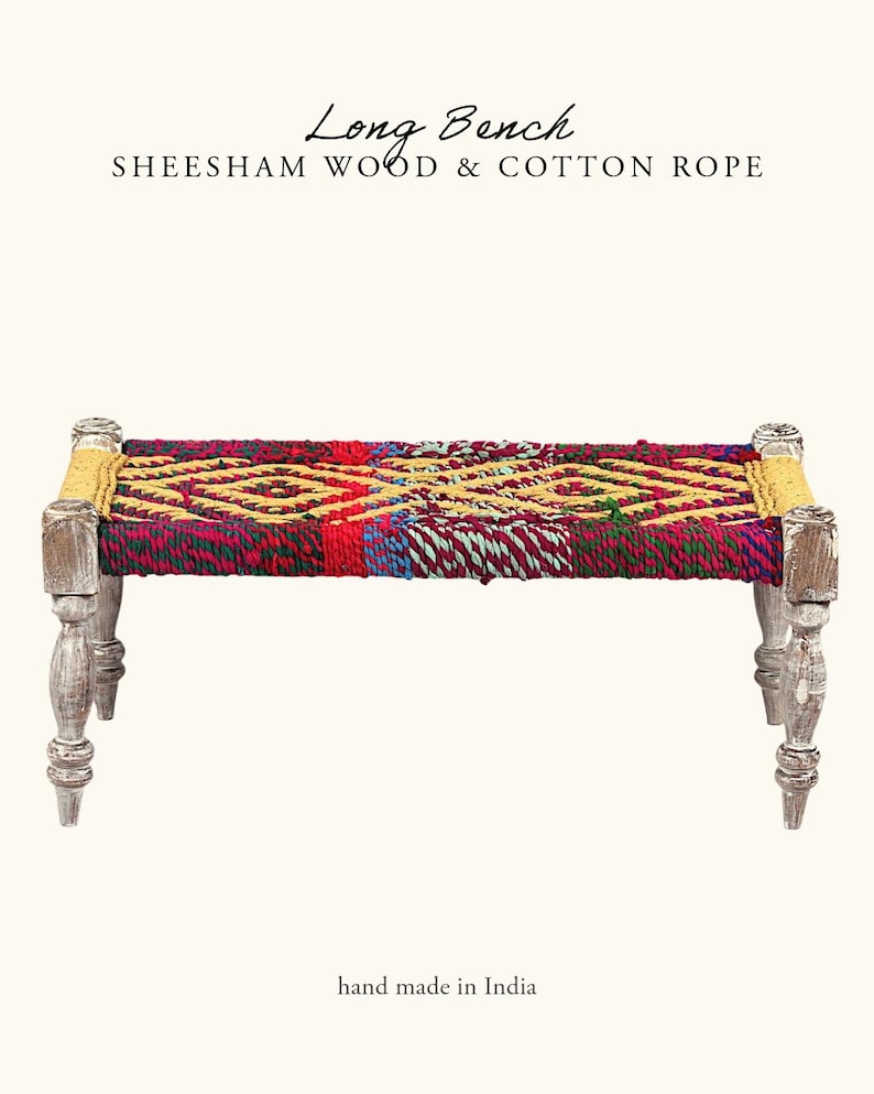 May include: A long bench made of sheesham wood and cotton rope. The seat features a colorful woven pattern in red, yellow, and blue. The legs are painted white. The text "Long Bench" and "hand made in India" are visible.