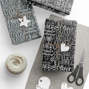May include: Three wrapped gifts with black and white "Oliver Happy Birthday" patterned paper. Each gift is tied with twine and a white tag. A ball of twine, scissors, and blank tags are also present.