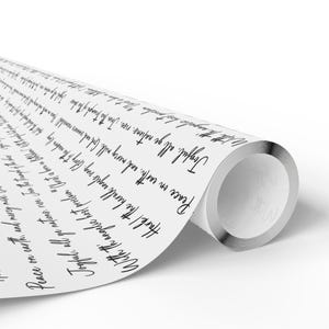 May include: A roll of white wrapping paper with black script. The text includes phrases like "Peace on earth" and "Joyful, all ye nations, rise." The paper has a metallic silver edge.