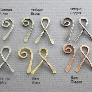 May include: Six pairs of wire ribbon ends in different finishes: antique brass, antique copper, bare brass, bare copper, and German silver. Each pair features a twisted wire loop and a straight wire end.