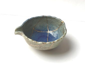 Liten blå och brun japansk katakuchikeramik, trasig och restaurerad med Kintsugi. Varje verk är unikt.