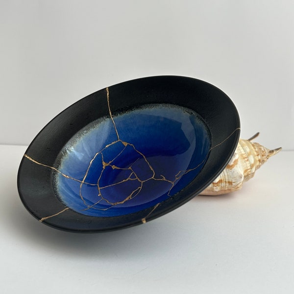 Élégant bol bleu et noir, céramique japonaise cassée réparée avec l'art Kintsugi. Idéal comme cadeau spécial et décoration d'intérieur avec style.