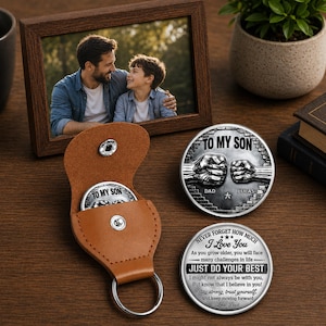 May include: A brown leather coin holder with a silver coin that says "TO MY SON". Two additional silver coins are visible, one with the text "TO MY SON" and the other with the text "JUST DO YOUR BEST". A framed photo of a father and son is also present.