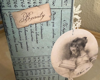 Può includere: Un collage in stile vintage con un libro mastro azzurro con testo francese scritto a mano e una piccola carta con la scritta "Beauty". Una stampa ovale color seppia raffigura una ragazza che legge, datata "28 marzo 1910".