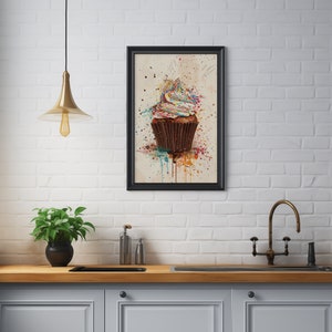 May include: A framed watercolour painting of a colourful cupcake with sprinkles on a white background.