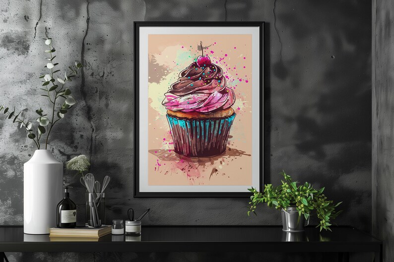 May include: A framed print of a colourful cupcake with pink and brown icing, a red cherry on top, and blue sprinkles. The cupcake is on a light brown background with watercolour splatters.