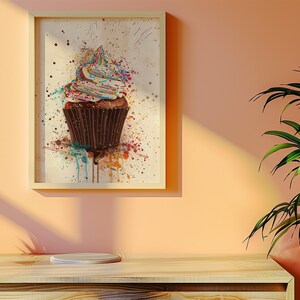 May include: A framed watercolour painting of a chocolate cupcake with white frosting and colourful sprinkles. The cupcake is surrounded by colourful paint splatters.