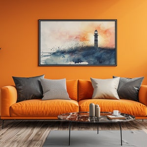 Puede incluir: Una pintura de acuarela de un faro en una playa al atardecer, colgada sobre un sof&aacute; naranja con almohadas en un ambiente de sala de estar.