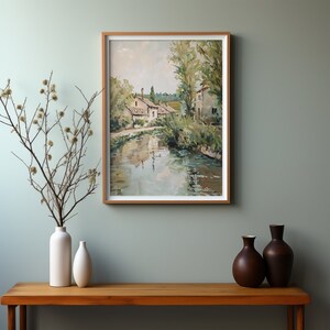 May include: A painting of a river scene with houses and trees on the banks. The water is a light blue and the sky is a light gray. The houses are white and the trees are green.