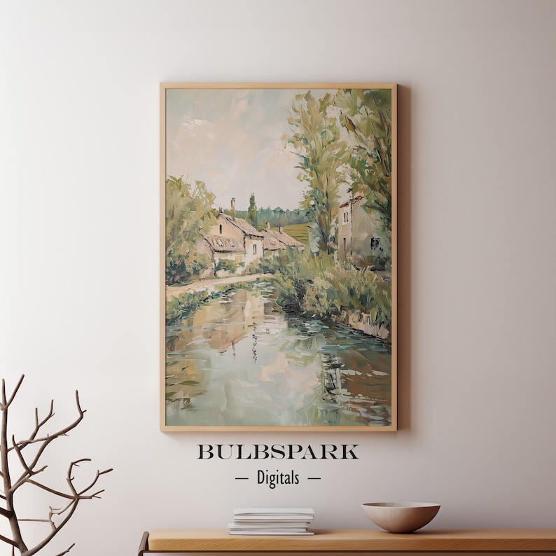 May include: A painting of a quaint village scene with houses along a river. The houses are painted in shades of beige and brown, with green trees and foliage surrounding them. The river is a calm blue-green, reflecting the sky and trees. The painting is done in a loose, impressionistic style, with visible brushstrokes.