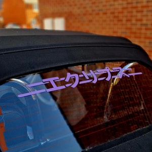 May include: A black convertible car with a purple vinyl sticker on the rear window that says "ニエカニコニ".