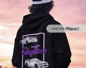 May include: Black hoodie featuring a purple and white graphic of two Nissan Skyline cars. The text "NISSAN Skyline" is in purple script. The person in the image is wearing a white baseball cap.