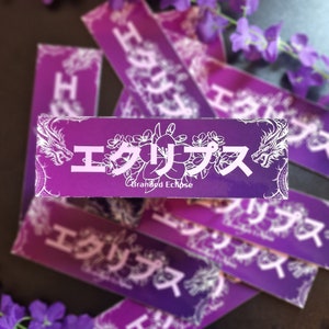 Könnte beinhalten: Ein Stapel violetter und weißer Aufkleber mit dem japanischen Text "エクリプス" (Eclipse) und den Worten "Branded Eclipse". Die Aufkleber zeigen einen Drachen und florale Designs.