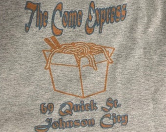May include: A gray t-shirt with a blue and orange graphic of a takeout container with noodles inside. The text "The Come Express" is above the container and "69 Quick St. Johnson City" is below the container.