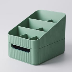 May include: A sage green organizer with multiple compartments. The organizer has a ribbed texture on the exterior and a handle on the front. The interior is divided into several sections, ideal for storing small items. The design is simple and functional.