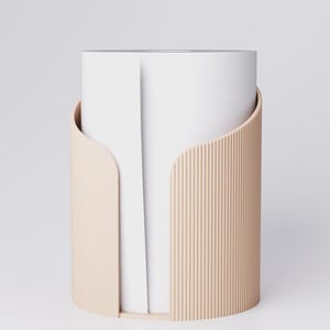 May include: A modern, minimalist paper towel holder. The holder features a cylindrical design with a light beige, ribbed exterior and a smooth, curved front. The interior holds a roll of white paper towels, creating a clean, contemporary look.