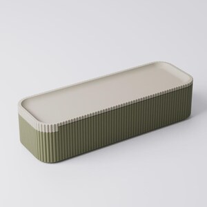 Peut inclure: Une bo&icirc;te de rangement rectangulaire avec une base vert olive c&ocirc;tel&eacute;e et un couvercle beige clair. Le couvercle a une surface lisse et un bord l&eacute;g&egrave;rement sur&eacute;lev&eacute;. La bo&icirc;te est con&ccedil;ue avec une esth&eacute;tique moderne et un style minimaliste.