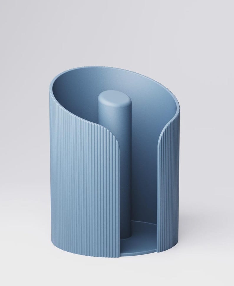 May include: A light blue paper towel holder with a vertical, ridged design on the exterior. The holder has a cylindrical center post and a curved top, creating a modern, minimalist aesthetic.