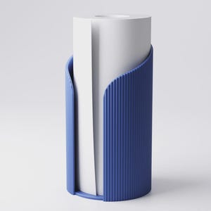 May include: A modern blue paper towel holder with a ribbed texture. The holder has a curved design that cradles a roll of white paper towels, creating a clean and minimalist aesthetic.