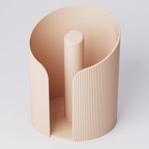 May include: A light peach-colored, cylindrical paper towel holder. The holder has a vertical, central post and a curved, ridged exterior. The design is minimalist and modern, suitable for kitchen or bathroom decor.